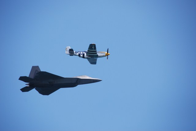 A thoroughly modern F-22 and a sixty year old P-51