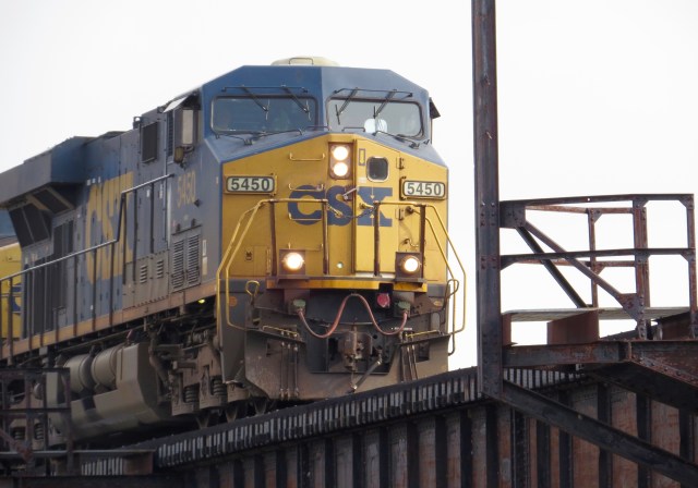 GE locomotive pulls a rare westbound train past the Federal Reserve and Brown's Island